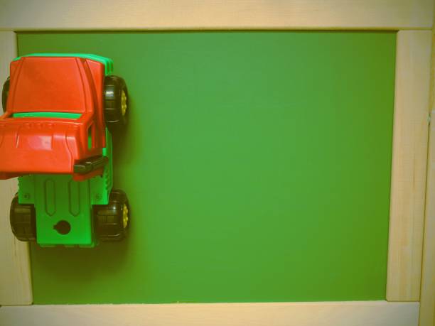 istock Green board and toy car. Top view. Toned image 682710438