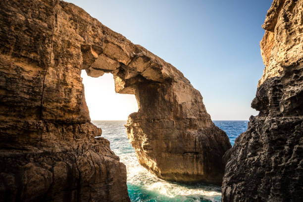 el arco de mar de piedra en wied il-mielah, gozo, malta. clima soleado, luz del sol brillante hora dorada. - gozo malta natural arch natural phenomenon fotografías e imágenes de stock