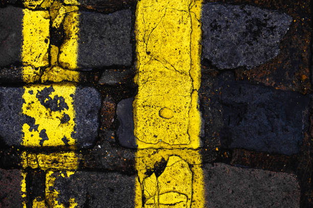 double yellow lines with cracked paint on a cobbled london street. vertical composition, rule of thirds. - two lane highway fotos imagens e fotografias de stock