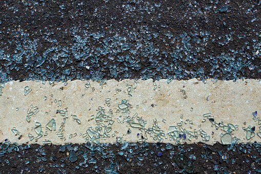 Glass falls on the road and broken. The shattered glass was spread out on the road. It be come dangerous must be careful while driving also created difference background and texture.