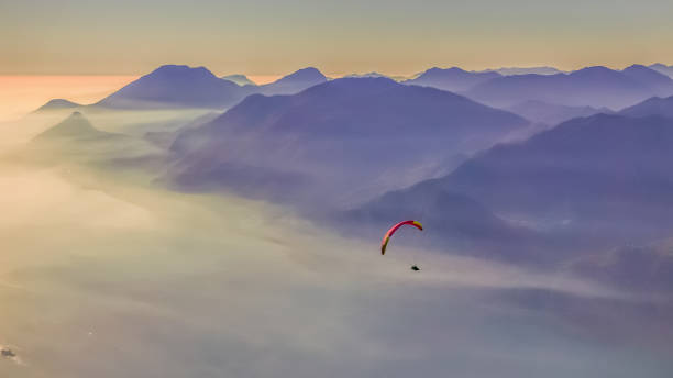 parapendio in volo sul lago di garda. - outdoors nature paragliding autumn foto e immagini stock