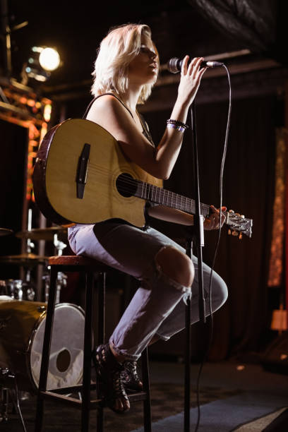 istock Performer singing while holding guitar at nightclub 682728570