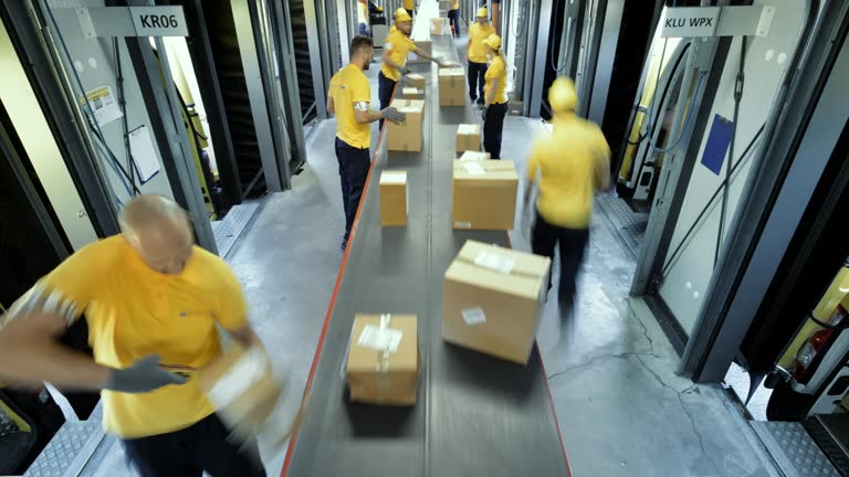 TIME-LAPSE Workers taking packages off the conveyor belt for further distribution