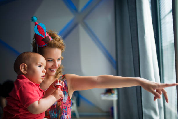 istock mother showing her baby at window 682746744