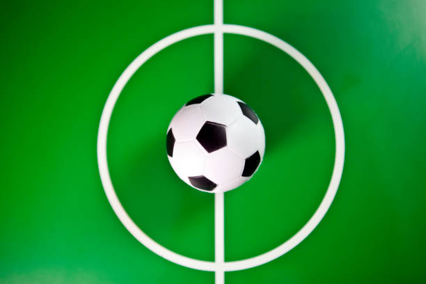 Toy soccerball in a midfield, in the center of the green field stock photo