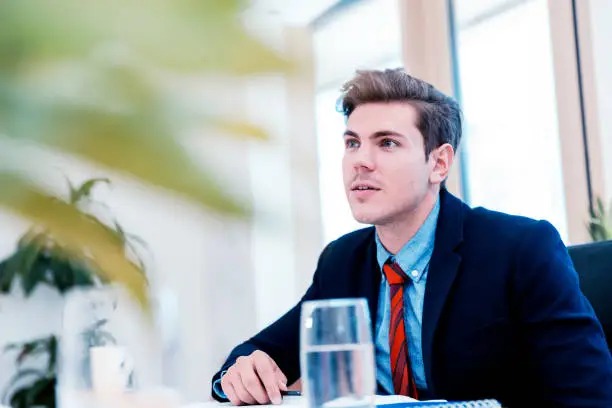 Poised young businessman chairing a business meeting.
