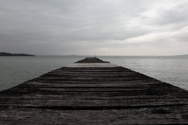 Free Stock Photo of Long Pier Extending Into the Ocean Under a Cloudy ...