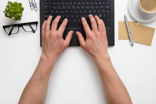 istock Businessman Using Laptop At White Desk In Office 682763048