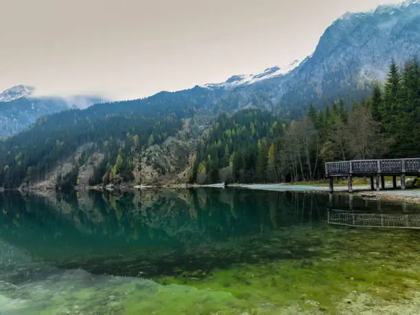 This beautiful lake is located on the border of Italy and Austria. This place is called South Tyrol. The perfect time of year for photography. Windless weather, light fog and temperature close to zero. Complete silence and tranquility.