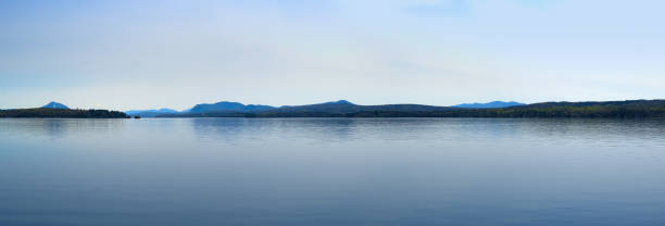 calm lake blue sky and water mountains Magog Québec calm lake, blue water and blue sky reflections mountains,  Magog Memphrémagog,  Québec lake magog photos stock pictures, royalty-free photos & images