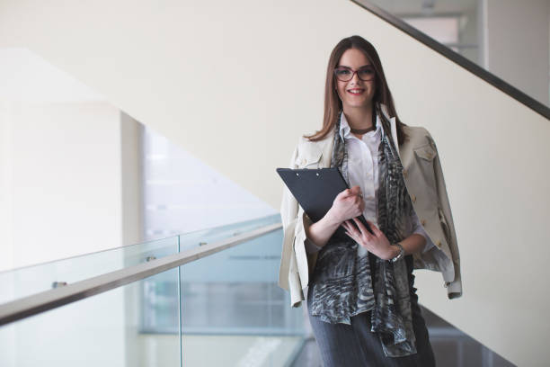istock Bussines women with documents in hands going down the stairs 682790128