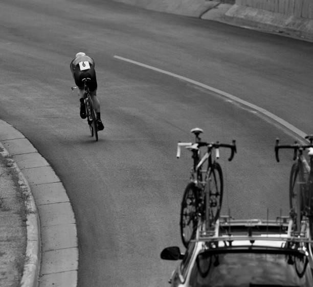 istock A man gets into an aerodynamic position while riding a downhill in a time trial during a profession road bike race. 682795358