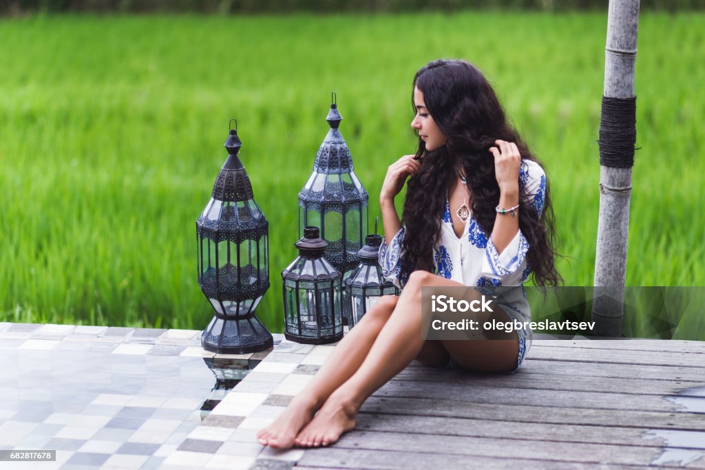 Young slim girl relaxing near luxury pool in Bali rice fields Active Lifestyle Stock Photo