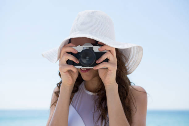 istock Close up woman wearing hat while photographing 682832274