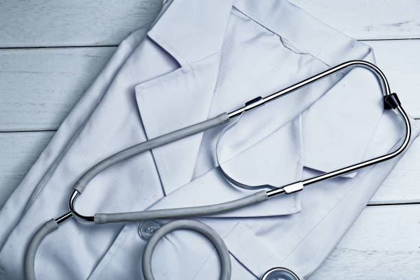 istock stethoscope,clipboard and doctor’s uniform on white neat wooden desk 682845398