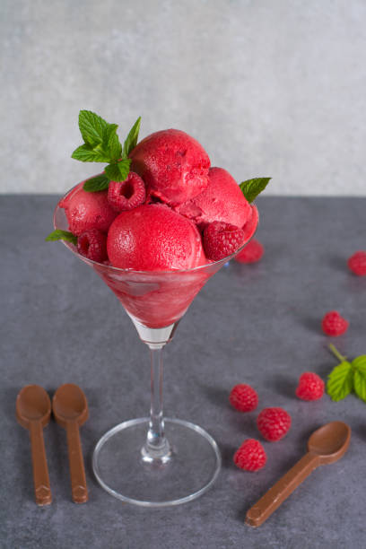 istock Raspberry ice cream sorbet in glass with chocolate spoon, raspberry, mint leaves  copy space 682876610