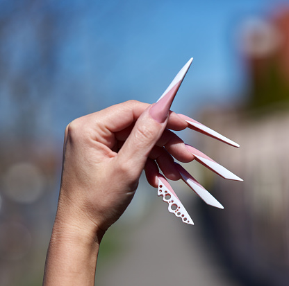 unrecognizable woman hand with long manicure, fashionable nails.photo taken outdoors.