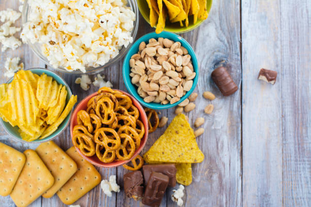 surtido de snacks poco saludables - pretzel snack salty food fotografías e imágenes de stock