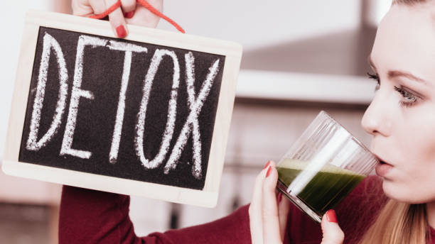 Woman holding vegetable juice and detox sign Drinks good for health, diet breakfast concept. Young woman in kitchen holding green healthy vegetable smoothie juice glass next to detox sign. Best Weed Detox Methods for 2025: What Actually Works? stock pictures, royalty-free photos & images