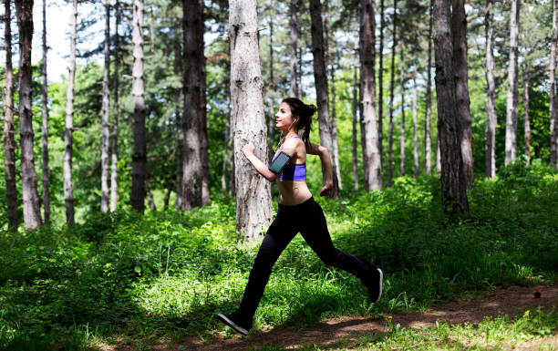 istock Young woman jogging in park 682893652