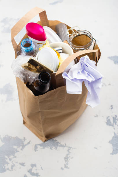 istock Craft paper bag with unsorted waste on white stone background 682896952