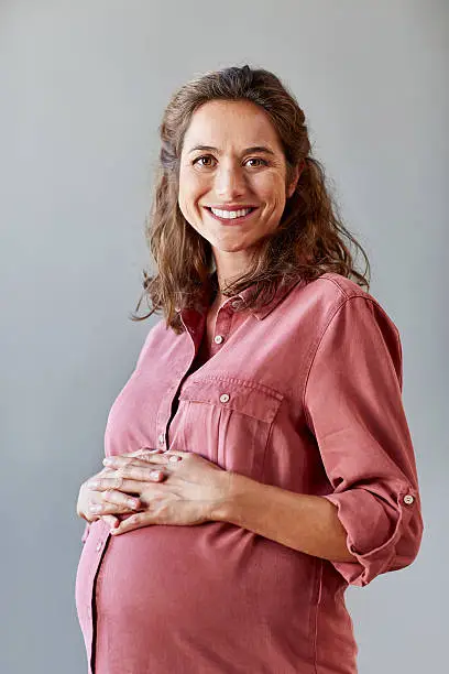Photo of Pregnant businesswoman with hands on stomach