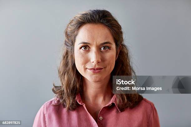 Confident Businesswoman Over Gray Background Stock Photo - Download Image Now - Women, Portrait, One Woman Only