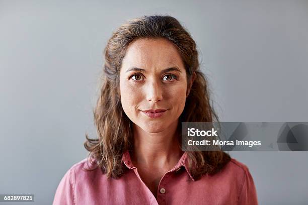 Confident Businesswoman Over Gray Background — стоковые фотографии и другие картинки Женщины - Женщины, Портрет, Только одна женщина