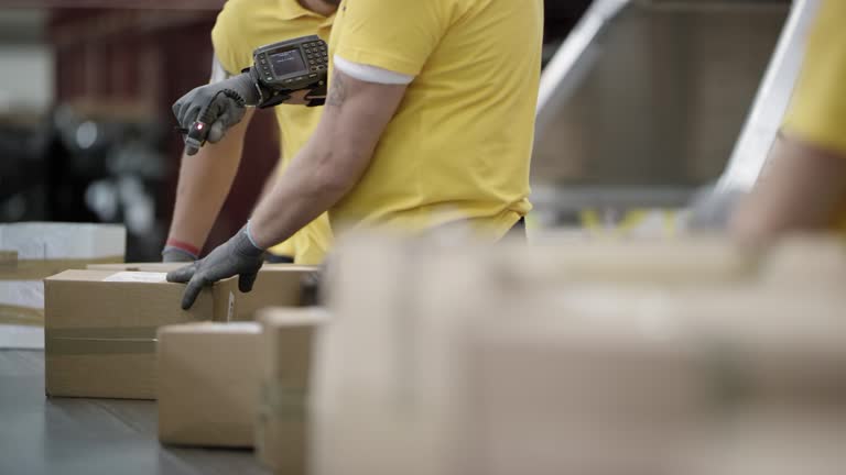 DS Postal employee scanning parcels on conveyor belt with a wearable ring barcode scanner