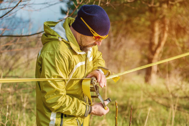 istock A man sets up slacklining equipment before doing crazy slacklining tricks and walking on slacklin in a park in the nature 682912222