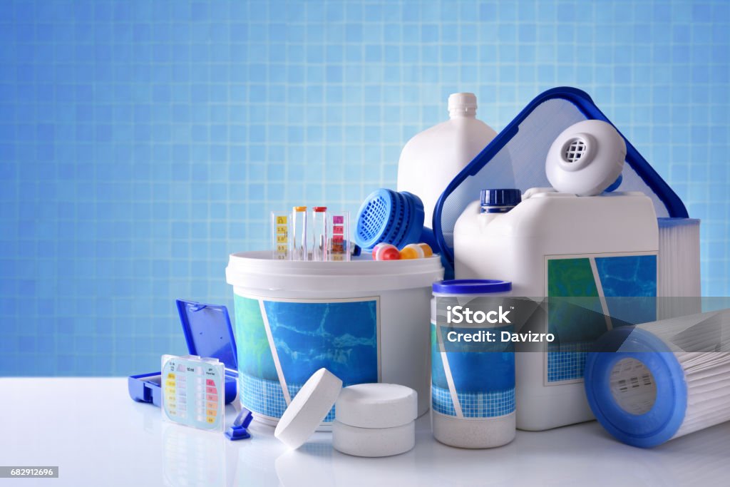 Chemical cleaning products for pool with blue mosaic background overview Chemical cleaning products for pool water on white table and blue mosaic background. Horizontal composition. Front view Swimming Pool Stock Photo