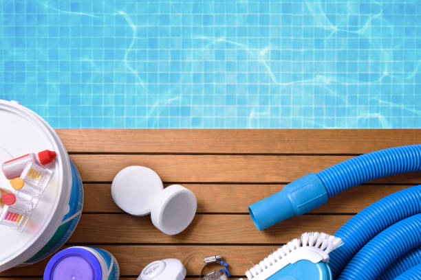 Chemical products and tools for pool maintenance Chemical products and tools for the maintenance of the pool on wooden slats. Pool with water and blue mosaics background. Horizontal composition. Top view chlorine stock pictures, royalty-free photos & images