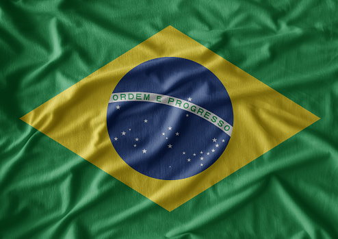 Brazilian Flag on cracked wall background.