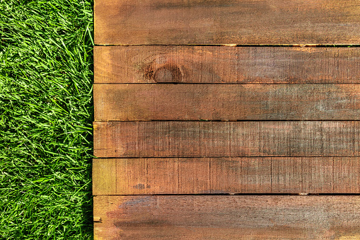 A wooden board on green grass, a template for picnic-related design, overhead shot