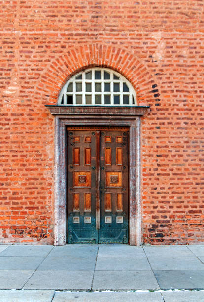istock Old vintage curch door with red brick wall 682923460