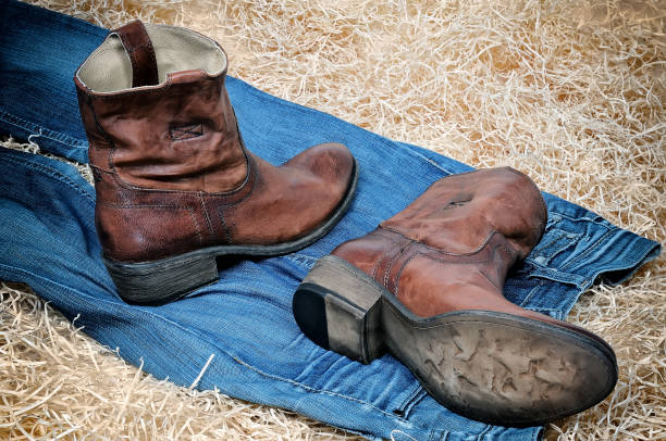 istock Leather cowboy boots and jeans on straw 682924208