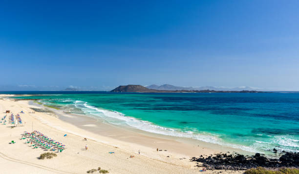 XXL panorama view of the islands of Lobos and Lanzarote seen from Corralejo Beach (Grandes Playas de Corralejo) on Fuerteventura, Canary Islands, Spain, Europe. Beautiful turquoise water & white sand. stock photo