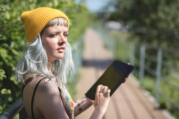 istock Young lady using her tablet outdoors 682931962