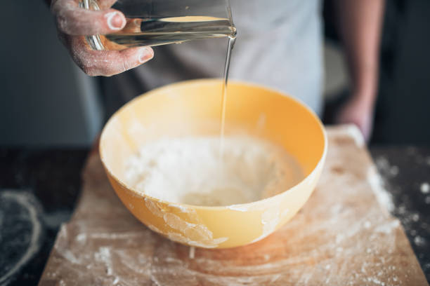 istock Male baker hands adds ingredients to the bowl 682936560