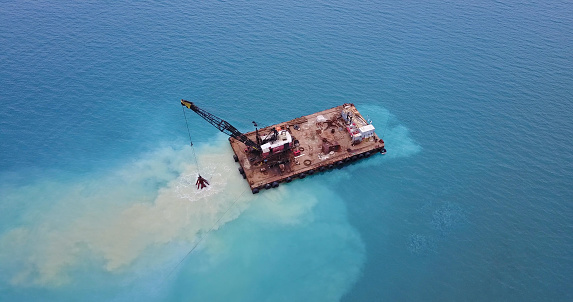 Barge lifts the sand using a ladle from the bottom of the sea. Landscape shot of drone. Mediterranean Sea. Cyprus