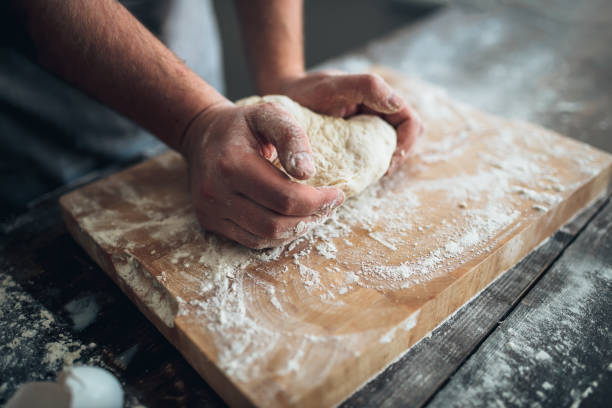 istock Baker hands kneading the dough with flour 682936874