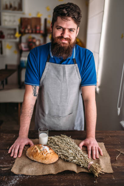 istock Baker against bread, wheat, milk on burlap cloth 682940266
