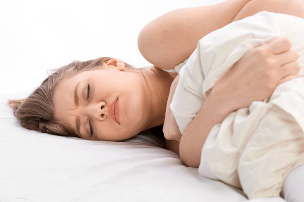 istock woman in bed with terrible stomachache 682940558