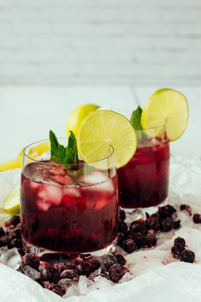 Berry cocktails with mint and lime in glasses