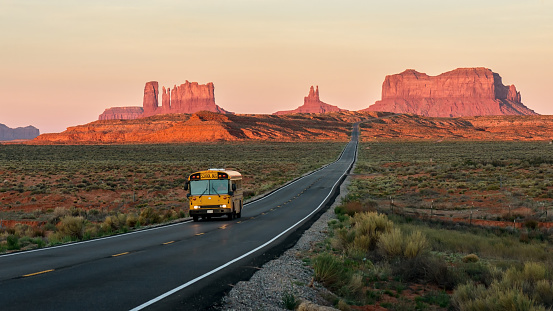 School bus and morning light on the rocks of Monument valley.\