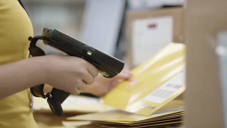 PAN Warehouse employee scanning envelopes with a handheld barcode scanner