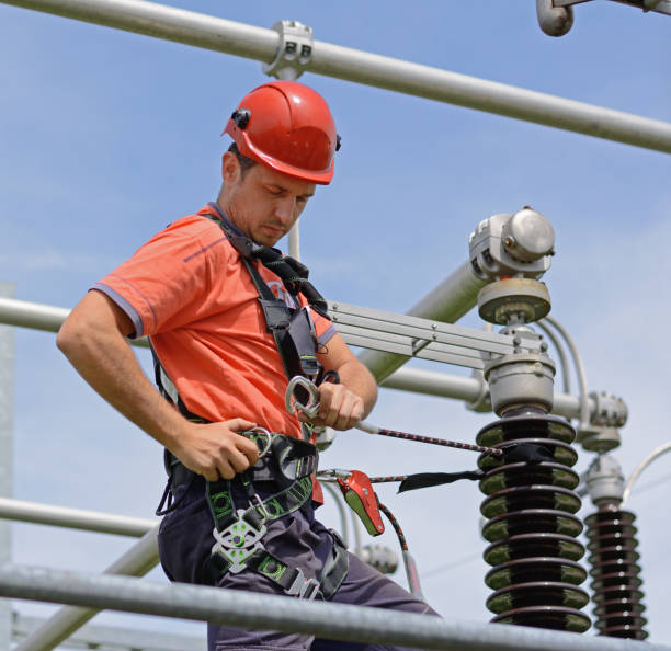 istock Electrician with protective workwear, hardhat and safety harness working 682958330