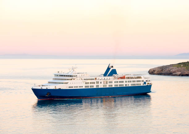 tramonto e traghetto bianco blu nelle isole greche - passenger ship ferry crane harbor foto e immagini stock