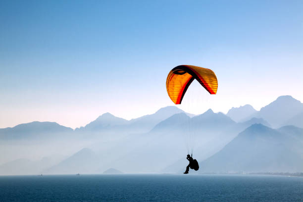 Paragliding Silhouetted in the mountains with paragliding. paraglider stock pictures, royalty-free photos & images