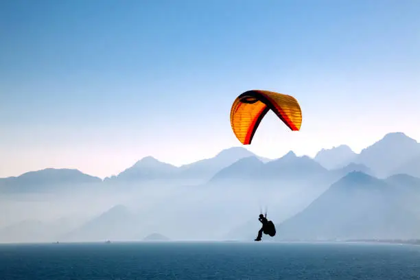 Silhouetted in the mountains with paragliding.